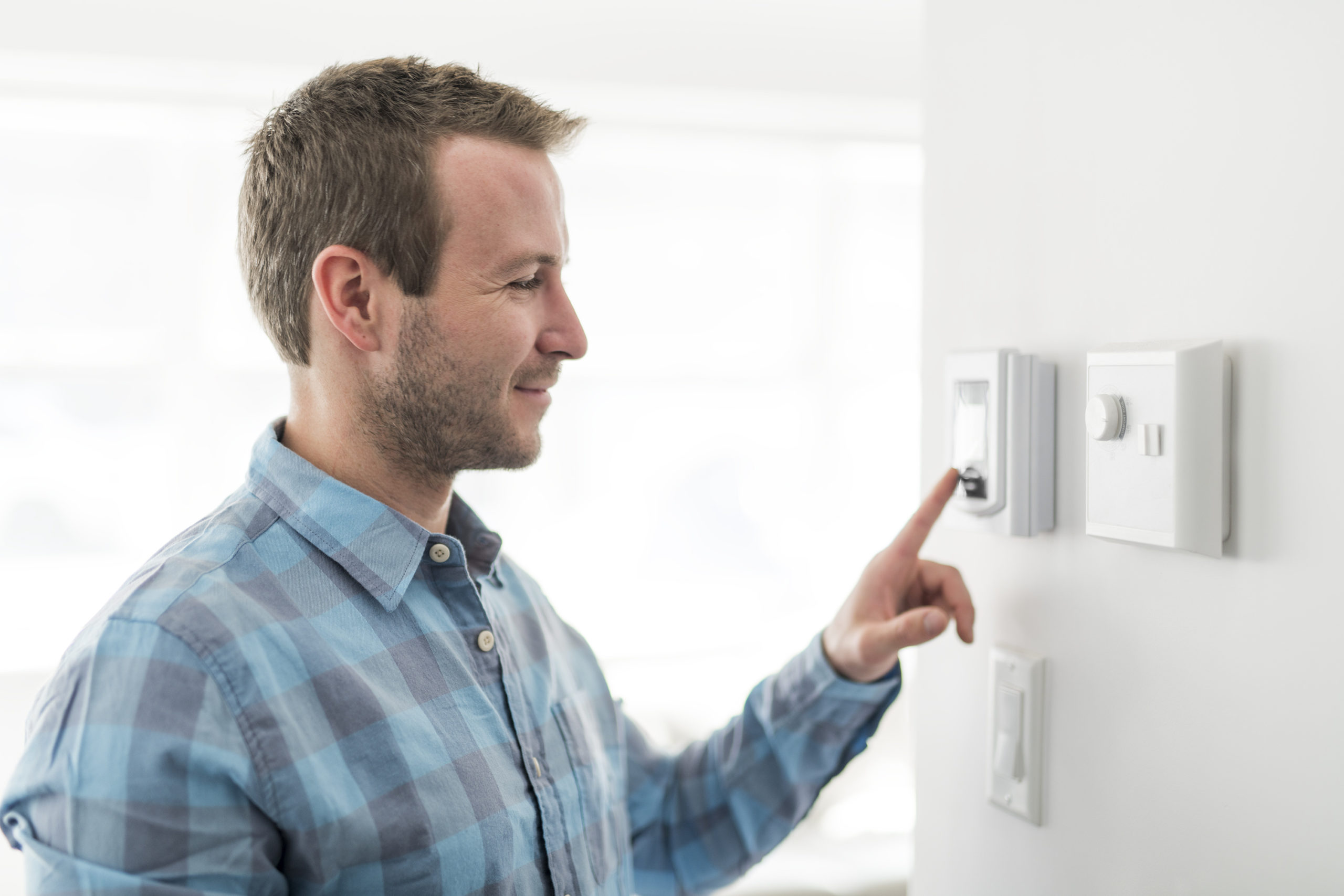 Man adjusting thermostat