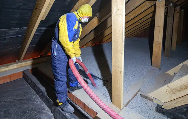 Technician installing insulation in attic